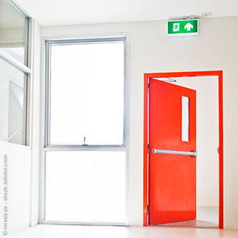rote Brandschutztür mit Notausgang-Schild