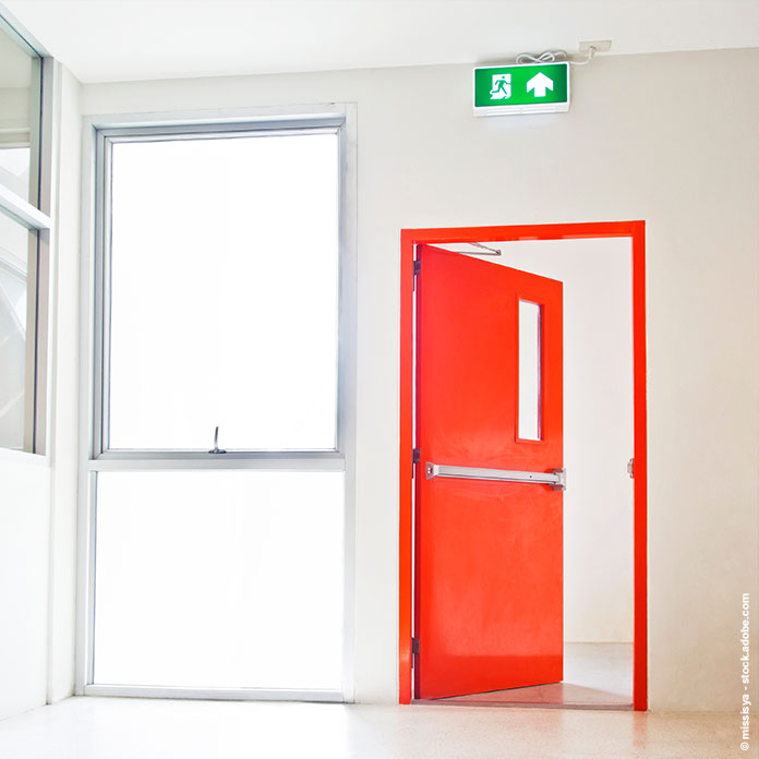 Rote Brandschutztür mit Notausgang-Schild