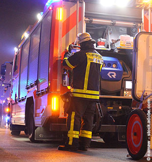 Löschfahrzeug mit Feuerwehrmann im Einsatz