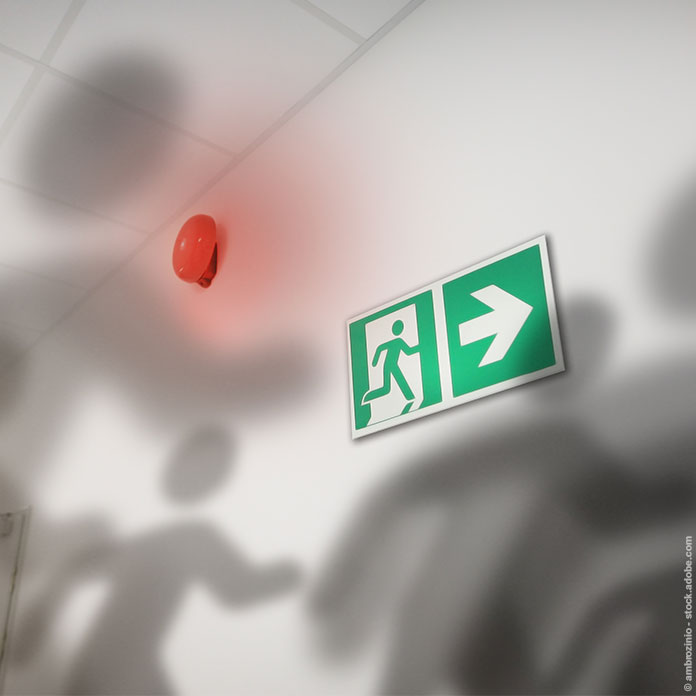 Smog und Rauch im Bürogebäude mit Schatten an der Wand und Notausgang-Beschilderung