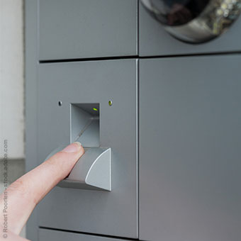 Ein Finger auf einem Fingerabdrucksensor einer Haustür zum öffnen der Tür